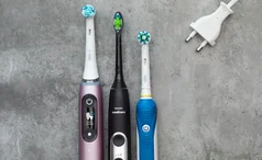 best electric toothbrush lead image: oral-b and phillips sonicare toothbrushes on grey background with charger
